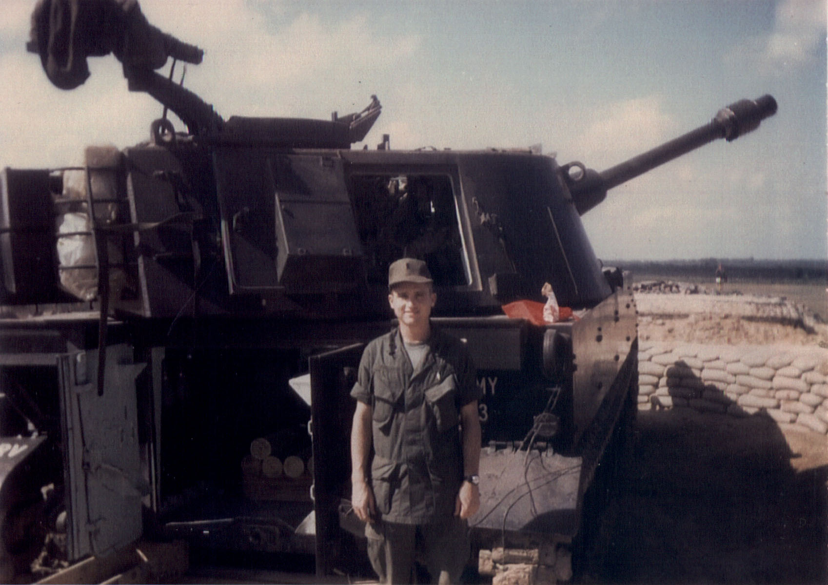 Patterson standing in front of a 105 self propelled Howitzer.