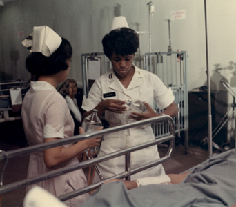 Cpt. Theora L. Peyton changes an intravenous saline bottle